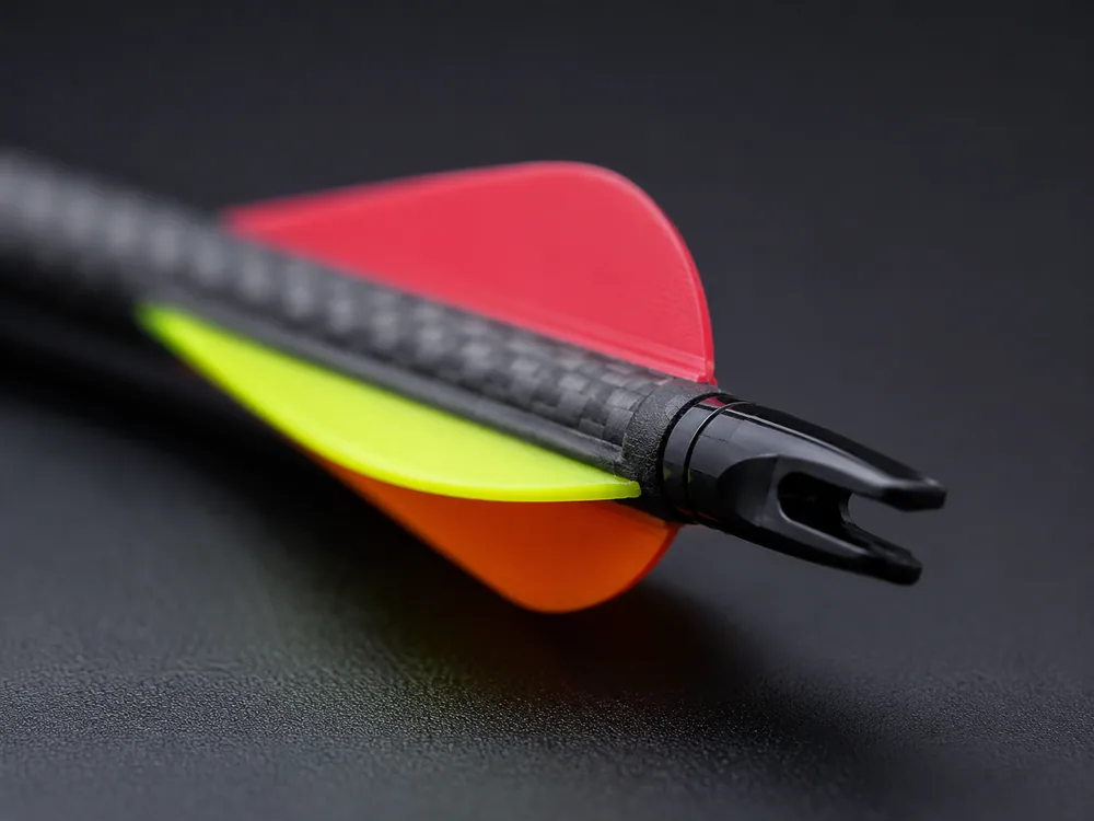 Close-up of the three colorful plastic vanes on the back of a carbon target arrow.